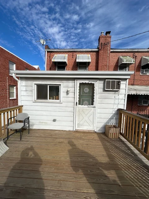 White painted house addition with new siding, trim, and door frame on wooden deck