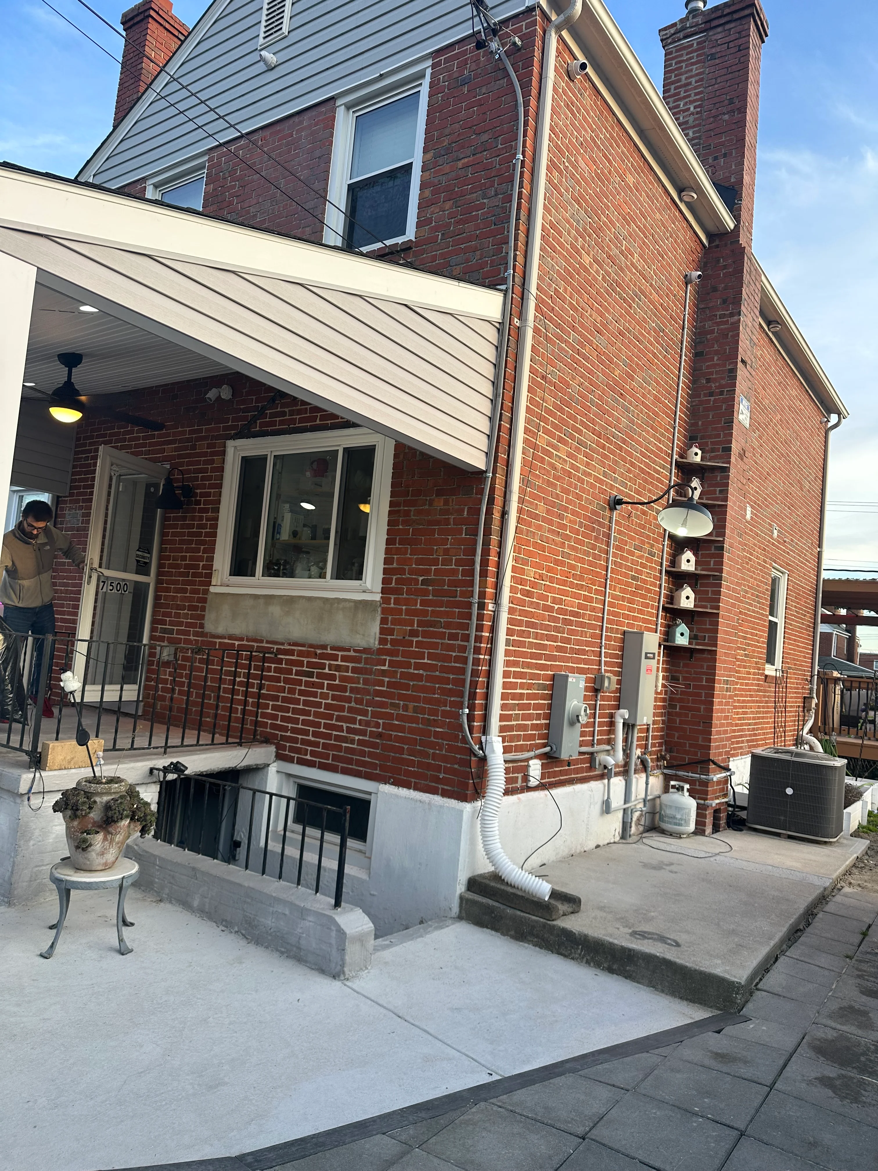 Brick home with newly painted white soffit and gray siding, professional exterior painting work